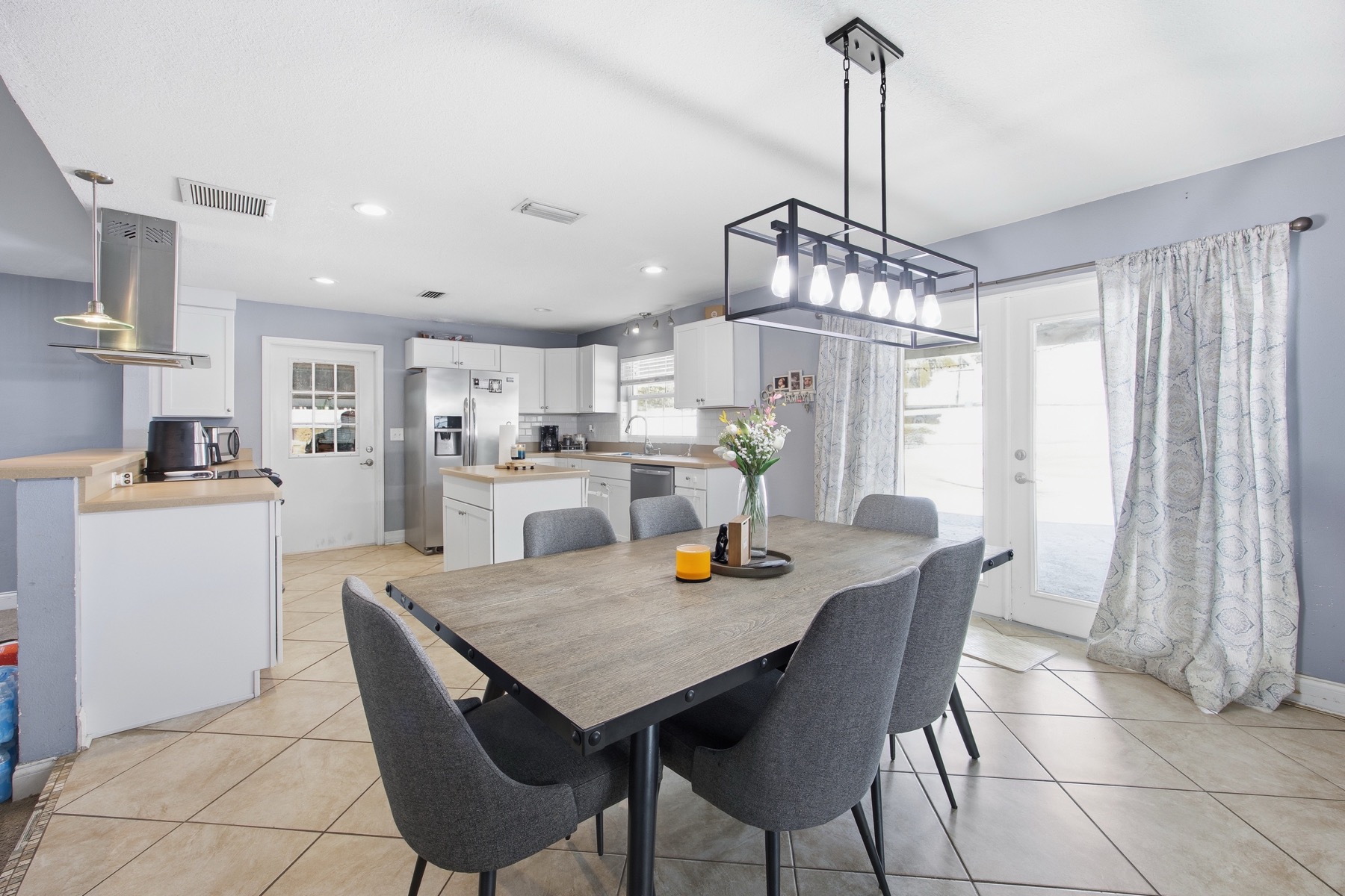 Open-plan dining room with modern pendant light and kitchen with stainless appliances at 2580 SE 37th St Ocala FL
