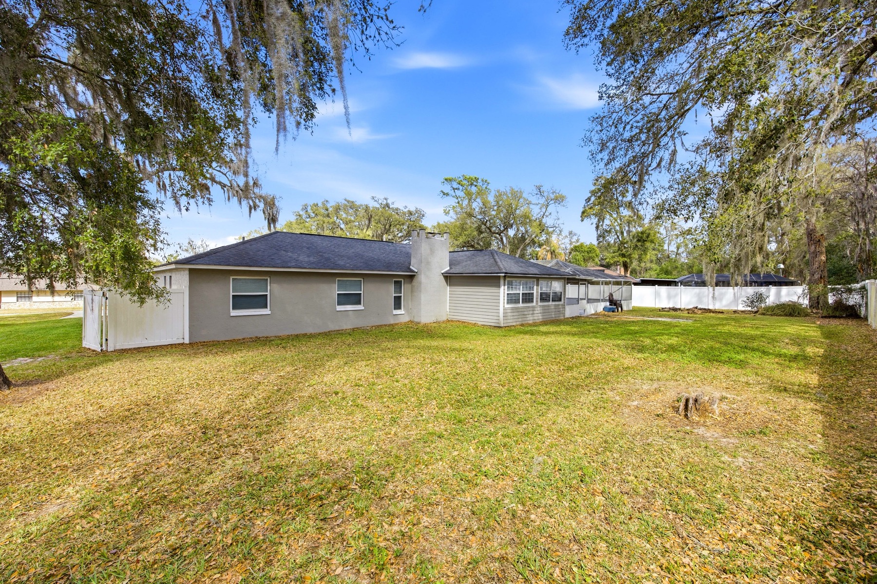 Large rear yard under Spanish moss oak trees at 2580 SE 37th St Ocala FL