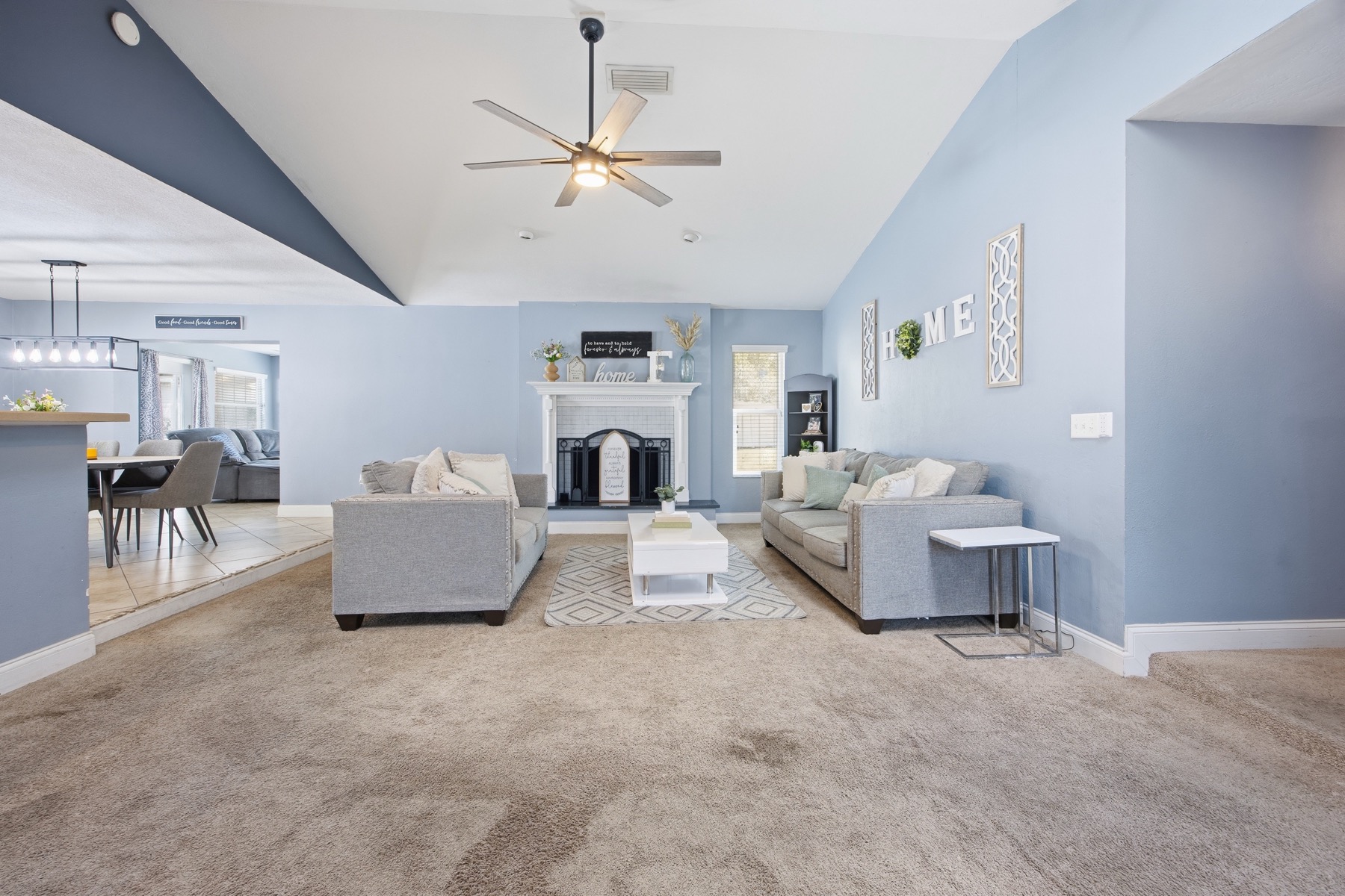 Living room with fireplace, vaulted ceiling, and ceiling fan at 2580 SE 37th St Ocala FL